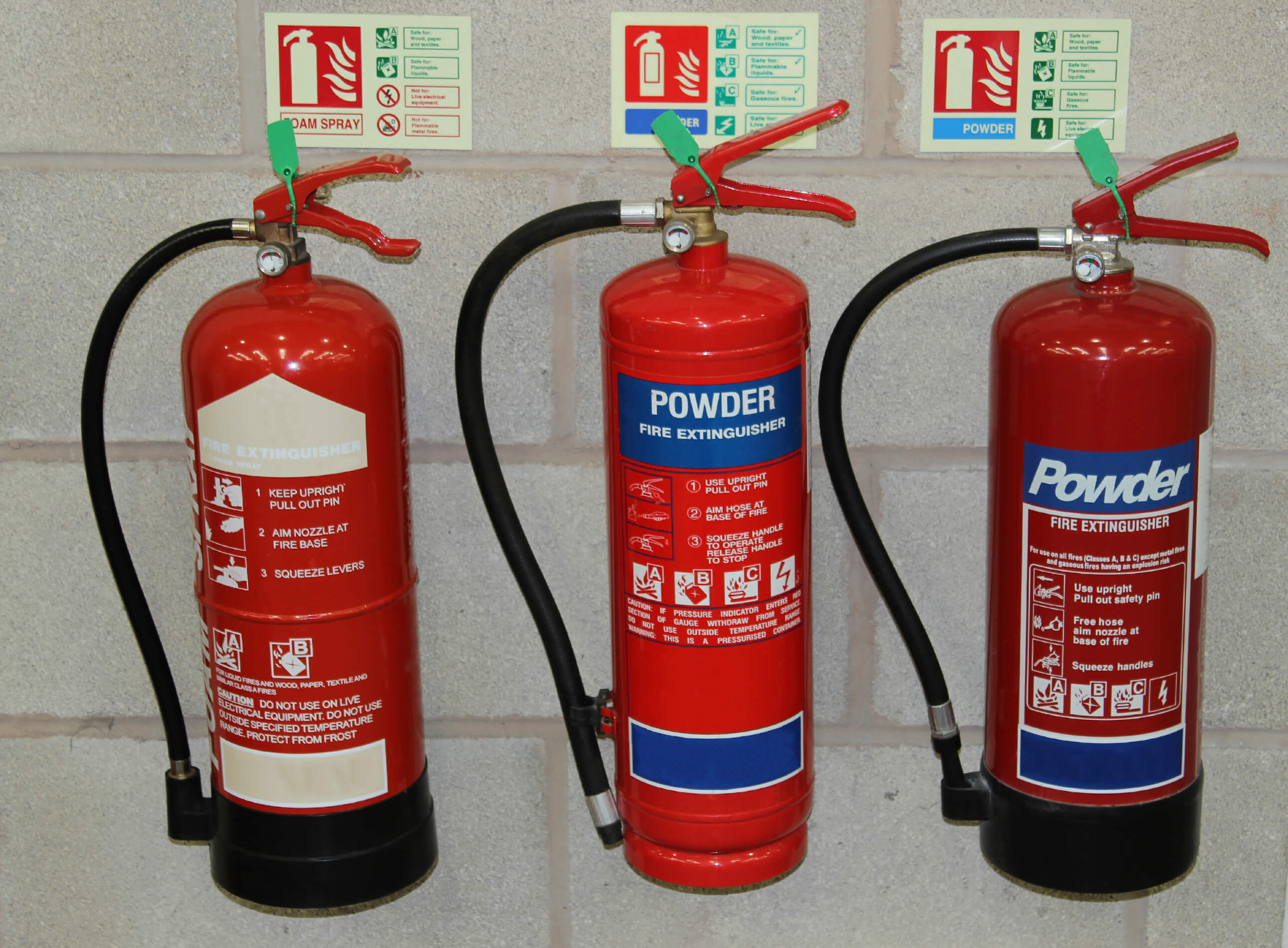 three fire extinguishers on the wall